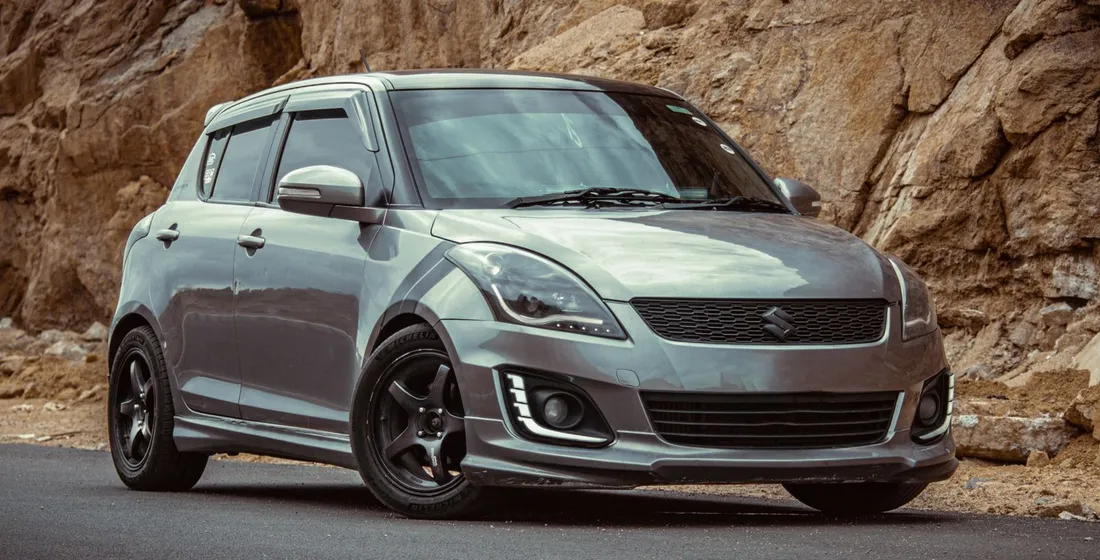 Suzuki Swift d'occasion grise stationnée en ville, vue trois quarts avant, photo de jour
